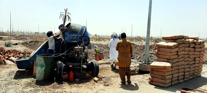 House 126 Sector R DHA Multan concrete mixer and cement stock at construction site by The Niaz Builders